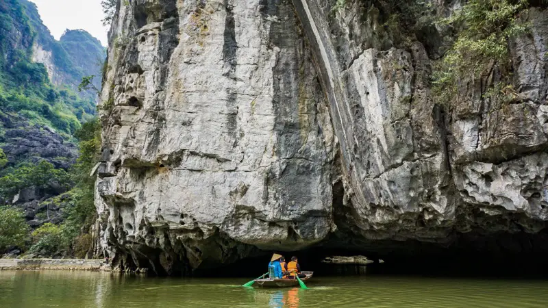 Rowboat is entering a cave in Tam Coc, Vietnam