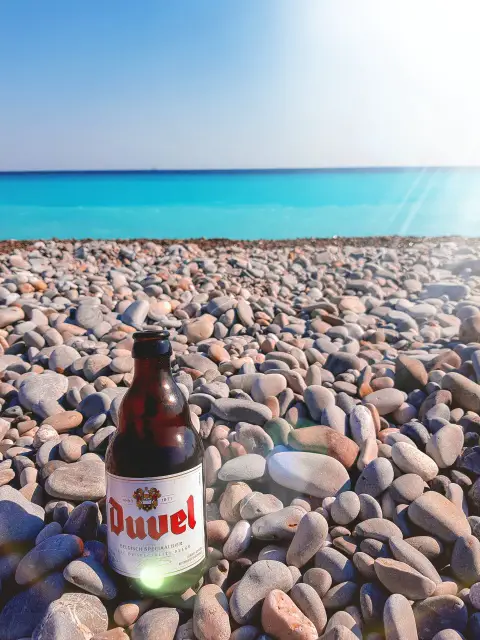 Enjoying a bottle of Duvel, Belgian beer, at the public beach in Nice, France