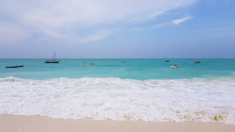 Turquoise waters splash against the white sand on Nungwi Beach, Zanzibar